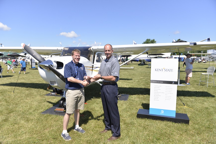 Doug May, vice president of Piston Aircraft presents Skyhawk keys to Stephen Pfanner, Kent State University chief flight instructor at Textron Aviation’s static display at the Experimental Aircraft Association (EAA) AirVenture.