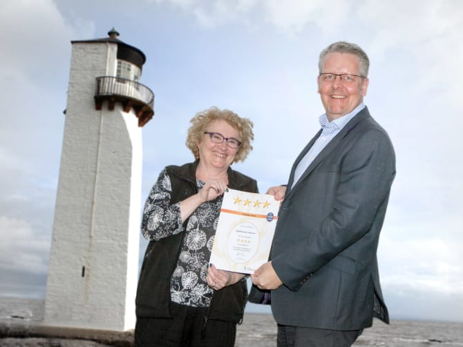 Sylvia Hunt from Lighthouse Leisure Caravan Park accepts the award from VisitScotland Regional Director Doug Wilson