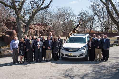 PHOTO CAPTION: Mid-America Chevy Dealers and Zoo officials gather before giraffes at the Saint Louis Zoo to mark the dealers’ multi-year partnership to support the Zoo’s conservation efforts and to show off a spacious new 2013 Chevy Traverse. On the left side of the car, from left, are Dealer/Bowling Green Chevrolet Robert Gilbreath; Zoo Vice President of External Relations Cynthia Holter; Dealer/Jim Butler Chevrolet Brad Sowers; Chevrolet District Sales Manager Paul Greenland; Dealer/Reno Guthrie Chevrolet Lisa Reno Guthrie; General Sales Manager/Elco Chevrolet Cort Howard; Chevrolet District Sales Manager Mike Sager; General Manager/Bommarito Chevrolet Mike Jordan; General Manager/Weber Chevrolet Jeff Kohler; Dealer/Weber Chevrolet Skip Weber; and Dealer/Jack Schmitt Chevrolet Kathy Schmitt-Federico, who isPresident of the Mid-America Chevy Dealers and stands next to Jeffrey P. Bonner, Ph.D., Dana Brown President & CEO of the Saint Louis Zoo. On the right side of the car are, from left, Chevrolet District Sales Manager Neka Spears; Dealer/Don Brown Chevrolet Don Brown; Promotional Coordinator Chris Barnhart; General Manager/Don Brown Chevrolet Greg Flotte; and Chevrolet Zone Manager Ken Sadowski.