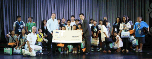 Mr Michael Goh, SVP of Sales, Star Cruises (right) presented a mock cheque amounting to  SGD$30,000 to Mr. Maurice Nhan, Board Director of the Children’s Wishing Well project, together with  the youth from the Children’s Wishing Well project onboard SuperStar Gemini.