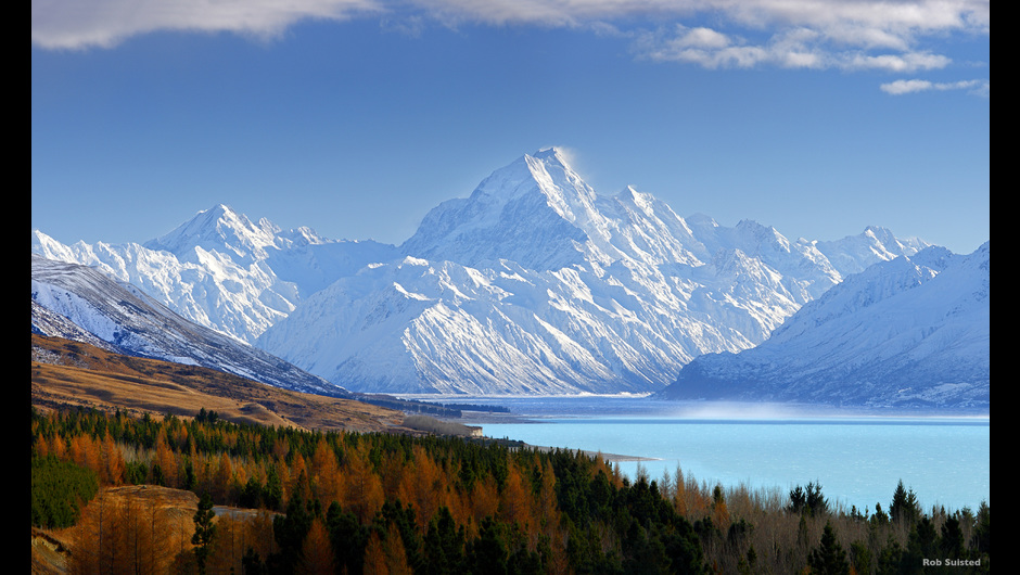 Lake Pukaki in Aoraki/Mount Cook National Park - location of Lake-town in The Hobbit Trilogy - in autumn is a spectacular vision of golden trees contrasted against opaque turquoise waters and the snow-covered Southern Alps. Credit: Tourism New Zealand / Rob Suisted