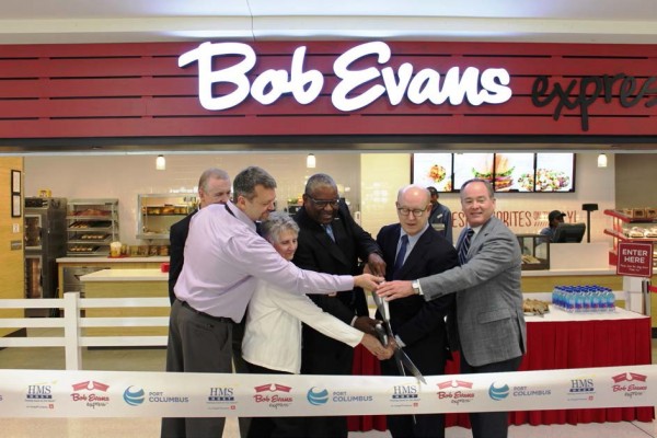 Cutting the ribbon, from left to right: Mike Townsley, President of Bob Evans Foods business unit, Bob Evans Farms Inc.; Kirk Christian, Senior Director of Operations, HMSHost; Gretchen Sandusky, Property Management Specialist, Columbus Regional Airport Authority; Derryl Benton, Executive Vice President of Business Development, HMSHost; Mark Hood, Chief Financial Officer, Bob Evans Farms Inc.; David Whitaker, Vice President of Business Development and Communications, Columbus Regional Airport Authority.