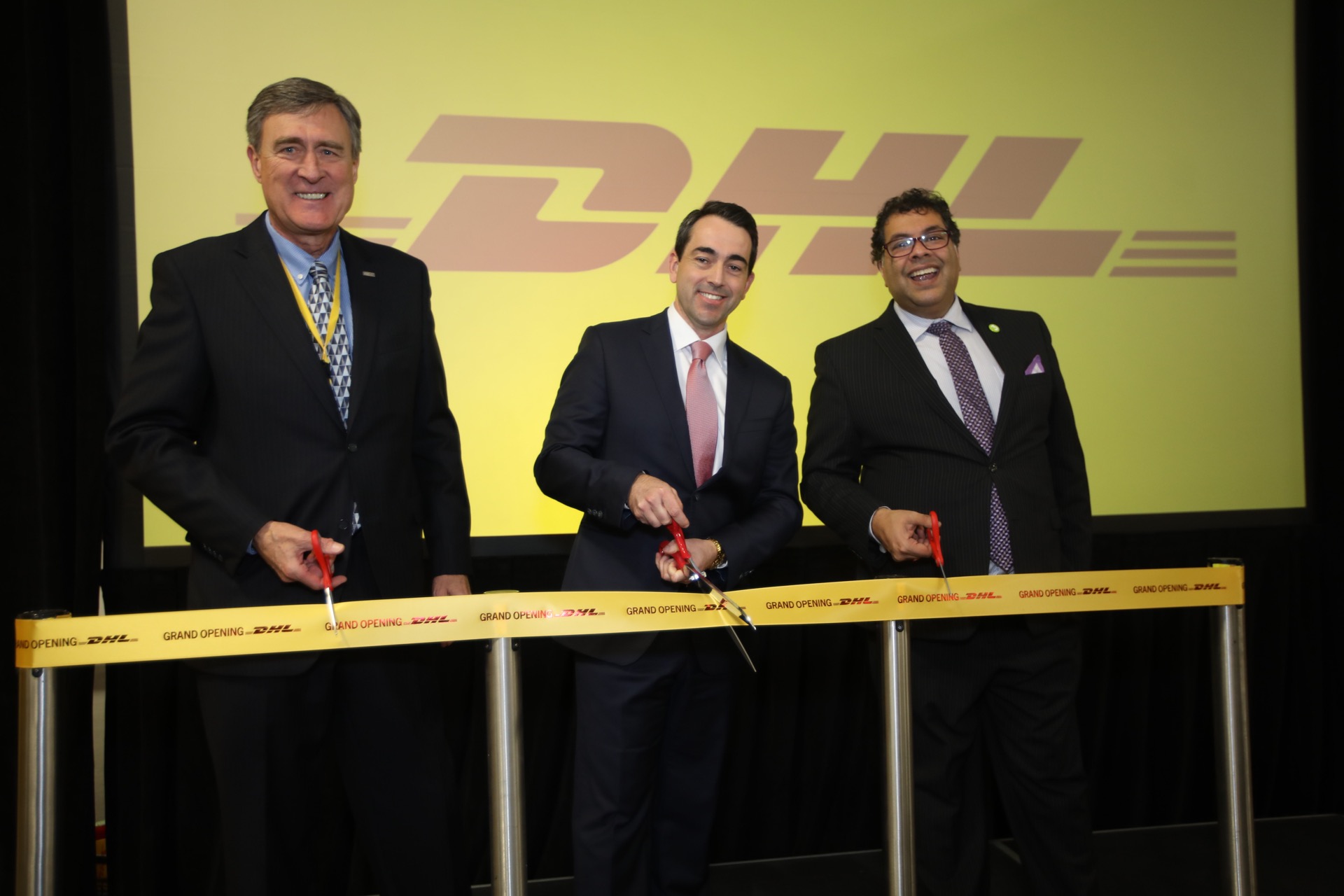 Pictured: Mel Belich, Calgary Airport Authority Board Chair (L) and His Worship Calgary Mayor Naheed Nenshi (R) join Andrew Williams, CEO of DHL Express Canada, in officially opening DHL’s expanded cargo facilities at YYC Calgary International Airport.