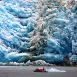 A zodiac cruising in front of a tidewater glacier in prince william sound Alaska.